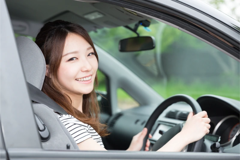 車に乗り込みこちらを微笑む女性